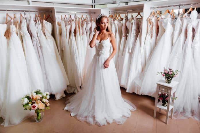 femme essayant une robe de mariée dans une boutique