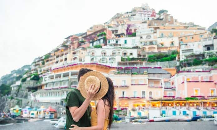 coupe s'embrassant derrière un chapeau pendant un voyage romantique au cinque terre