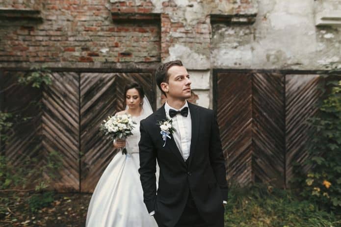 homme en costume de mariage devant une mariée
