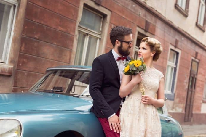 couple de mariés près d'une voiture pendant un mariage thème vintage
