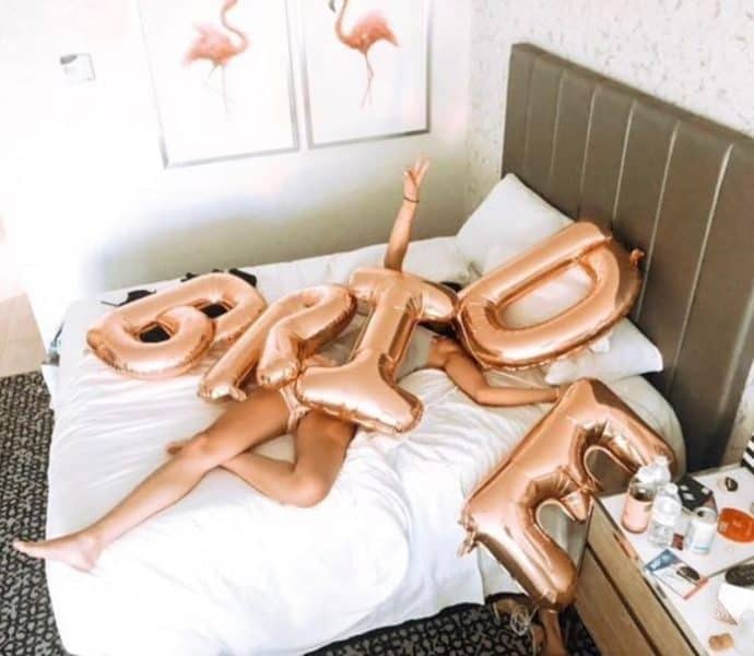 femme sur un lit pendant un EVJF avec les lettres BRIDE