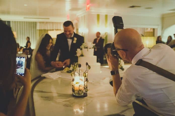 photographe prenant une photo des mariés pendant un mariage