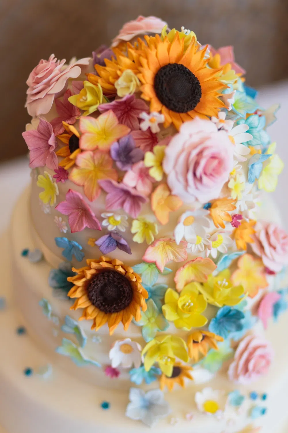 gâteau de mariage recouvert de fleurs en sucre colorées